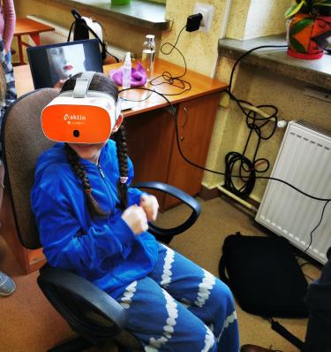 Uczennica w goglach VR wykonuje ćwiczenie