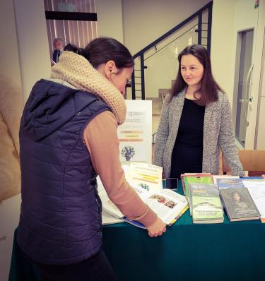 Uczestniczka przegląda wyeksponowane książki i roczniki czasopism wchodzące w skład zasobów PBW w Przemyślu i Filii w Jarosławiu.