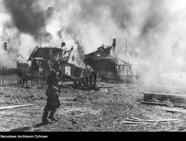 Płonąca wieś na froncie wschodnim. Podpalona przez niemieckich żołnierzy w celu przełamania oporu przebywających tam partyzantów. Fot. Obermuller, Źródło: nac.gov.pl