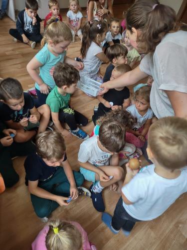 Zajęcia z jarosławską filią- bibliotekarka rozdaje dzieciom papierowe kropki