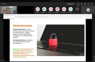 Skrin z przebiegu szkolenia - u góry ekranu prowadząca oraz częściowa lista uczestników, poniżej slajd z prezentacji (definicja cyberbezpieczeństwa)