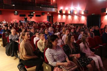 Siedzący na widowni ludzie z zainteresowanie patrzący na scenę JOKIS