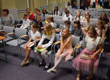 Siedzący na widowni uczniowie jarosławskich szkół i nauczyciele z zainteresowaniem patrzą na scenę, na której recytatorzy prezentują wiersze M. Konopnickiej.  