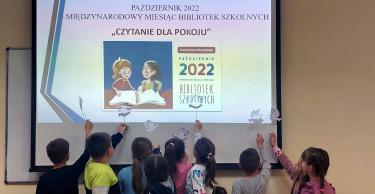 Uczniowie z Ujkowic podczas spontanicznej zabawy "gołąbkami pokoju" (fruwające cienie na rozświetlonym ekranie)