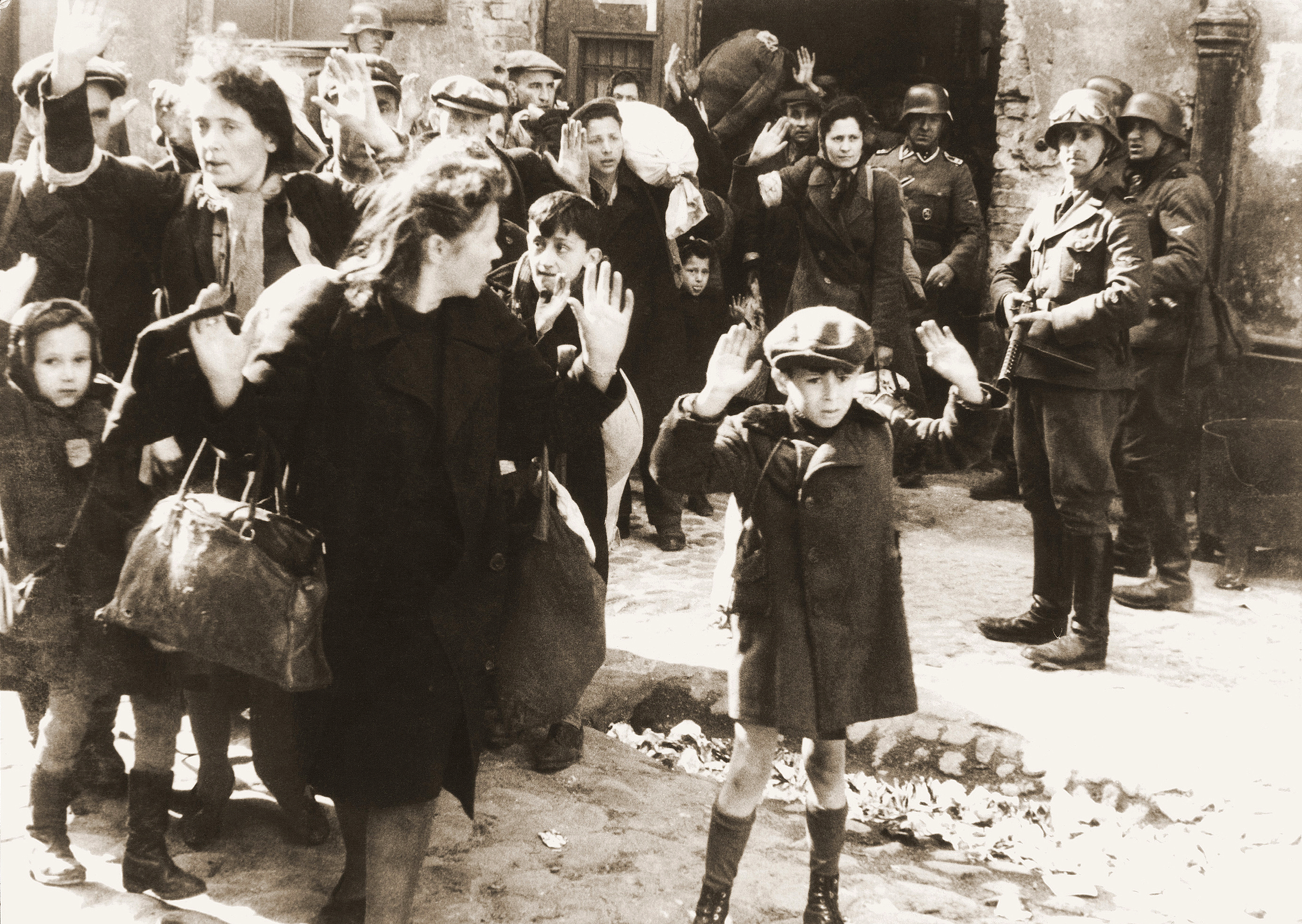 Żydowska ludność cywilna schwytana podczas tłumienia powstania. Oryginalny niemiecki podpis: „Siłą wyciągnięci z bunkrów” (fotografia z raportu Stroopa). Żródło: pl.wikipedia.org (domena publiczna)